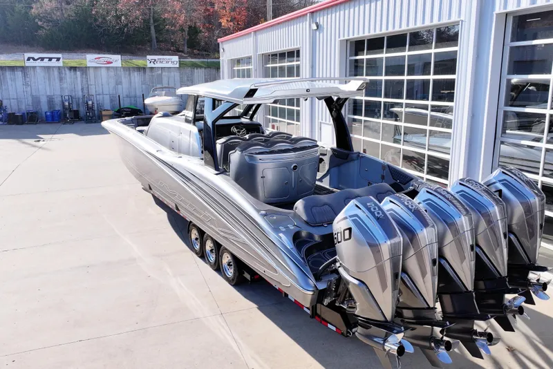 Slide: The Image of 2024 MTI 50v boat with five powerful outboard engines, parked outside a garage. - 62