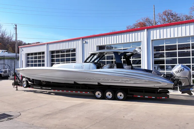 Slide: The Image of 2024 MTI 50v boat on trailer outside a garage, featuring sleek design and powerful engines. - 63