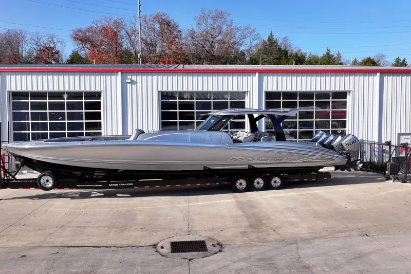 Slide: The Image of 2024 MTI 50v boat on trailer outside a garage, featuring sleek design and powerful engines. - 67