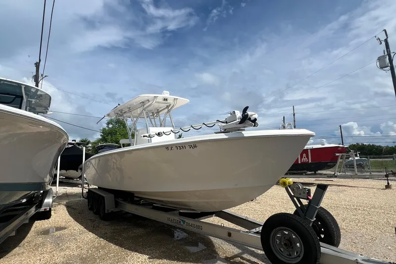 The Image of 2012 SeaHunter 29 boat on trailer under a partly cloudy sky. - 1
