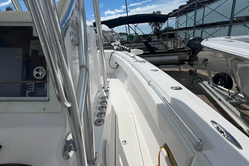 Slide: The Image of 2012 SeaHunter 29 boat interior with rod holders and console, docked near other boats. - 15