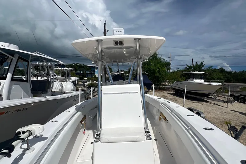 Slide: The Image of 2012 SeaHunter 29 boat with center console and T-top, docked under cloudy skies. - 19