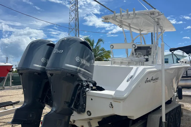 Slide: The Image of 2012 SeaHunter 29 boat with twin Yamaha 250 engines, parked outdoors under a blue sky. - 6