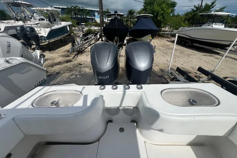 Slide: The Image of 2012 SeaHunter 29 boat with twin 250 horsepower engines, docked in a marina. - 8