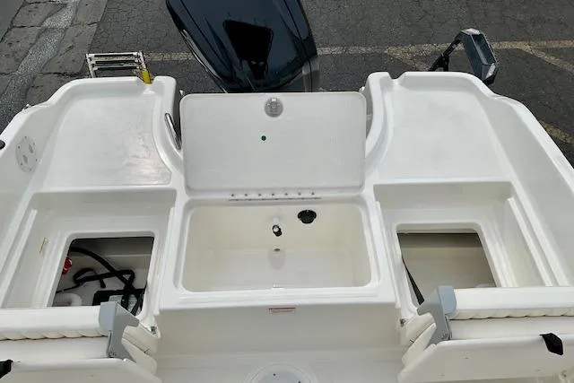 Slide: The Image of 2025 Bayliner Trophy T18 boat deck with storage compartments and motor. - 15