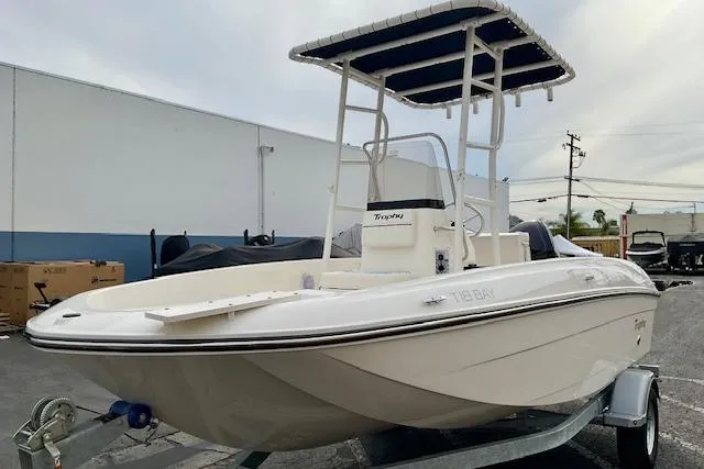 Slide: The Image of 2025 Bayliner Trophy T18 boat with T-top on trailer, parked outdoors. - 7
