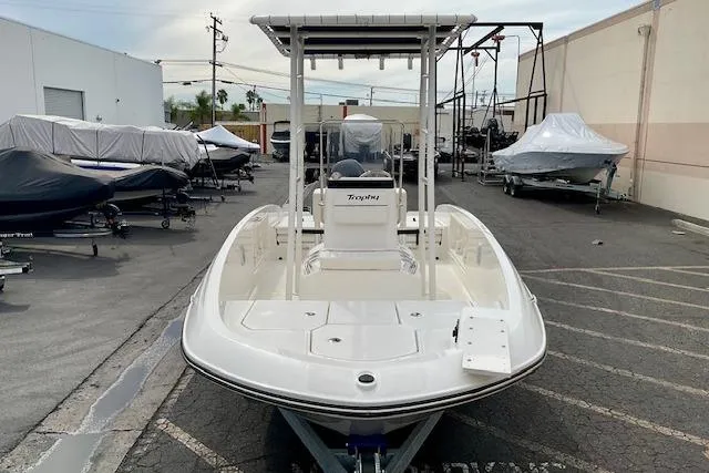 Slide: The Image of 2025 Bayliner Trophy T18 boat in a marina, surrounded by covered vessels. - 8