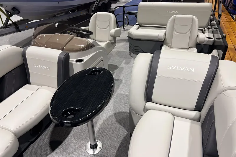 Slide: The Image of 2026 Sylvan Mirage 820 CLZ DH boat interior with luxurious seating and sleek table design. - 6