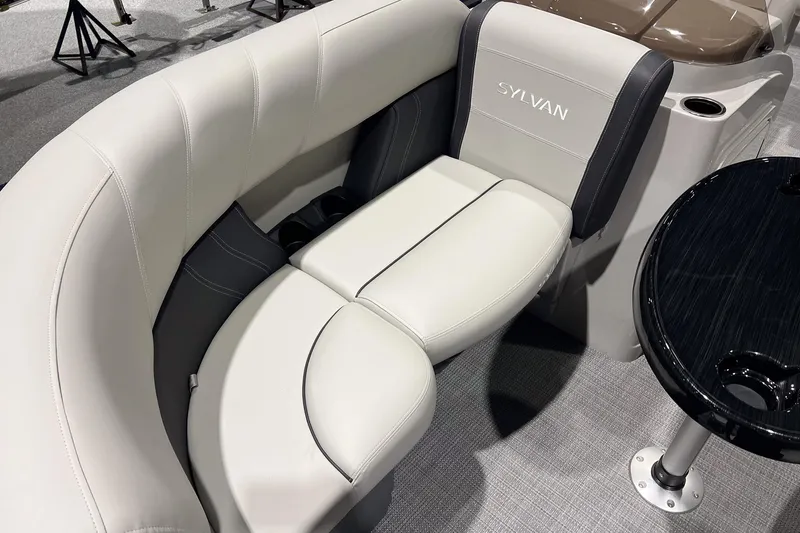 Slide: The Image of 2026 Sylvan Mirage 820 CLZ DH boat interior with plush seating and sleek table design. - 8