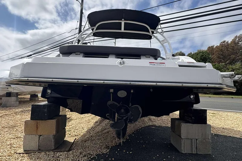 Slide: The Image of 2023 Monterey M-22 boat on blocks, rear view, under a cloudy sky. - 21