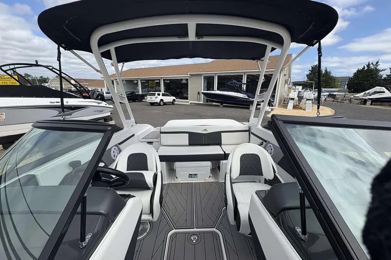 Slide: The Image of 2023 Monterey M-22 boat interior with seating and steering wheel, displayed at a dealership. - 8