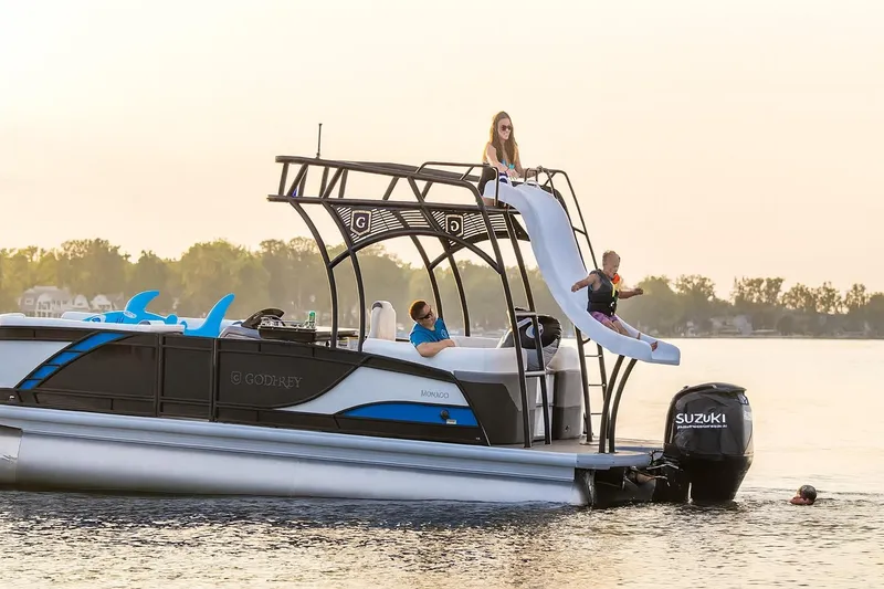 Slide: The Image of 2026 Godfrey Monaco 235 Sun Deck boat with 250 horsepower engine, showcased indoors. - 2