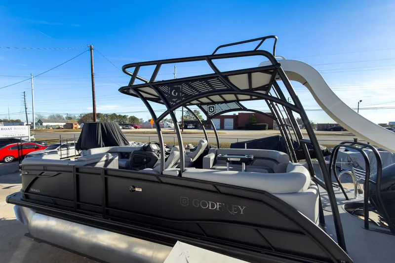 Slide: The Image of 2026 Godfrey Monaco 235 Sun Deck boat with sleek design and slide, docked outdoors. - 31