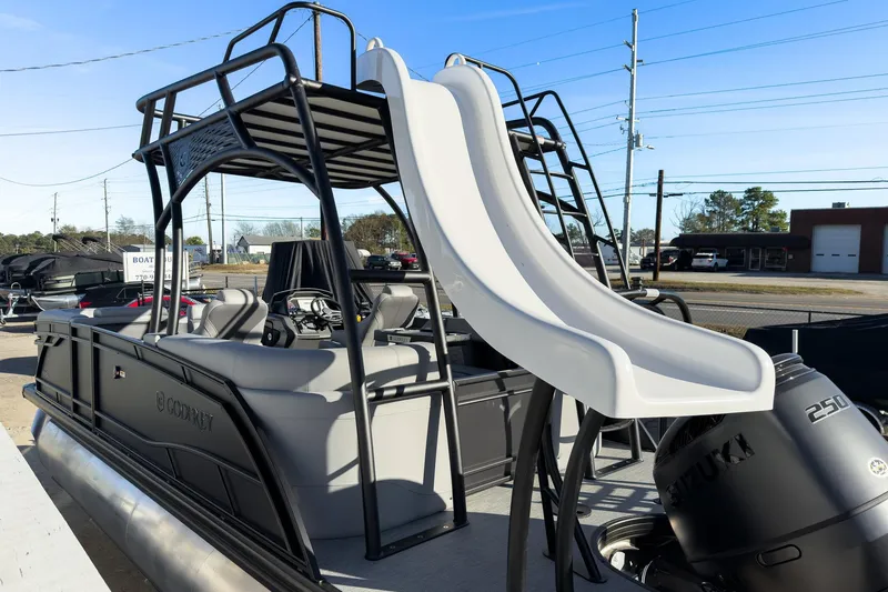 Slide: The Image of 2026 Godfrey Monaco 235 Sun Deck boat with slide and Suzuki engine, docked outdoors. - 32