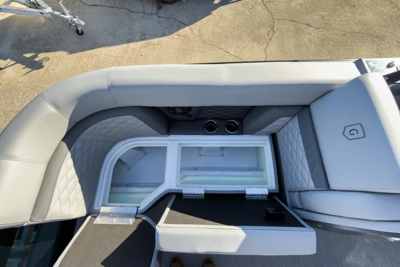 Slide: The Image of 2026 Godfrey Monaco 235 Sun Deck interior with open storage compartment and cushioned seating. - 42