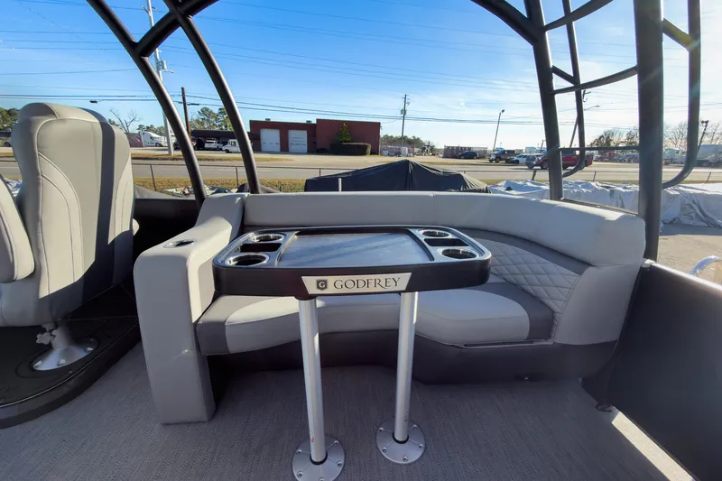 Slide: The Image of 2026 Godfrey Monaco 235 Sun Deck interior with seating and table, showcasing modern design. - 58