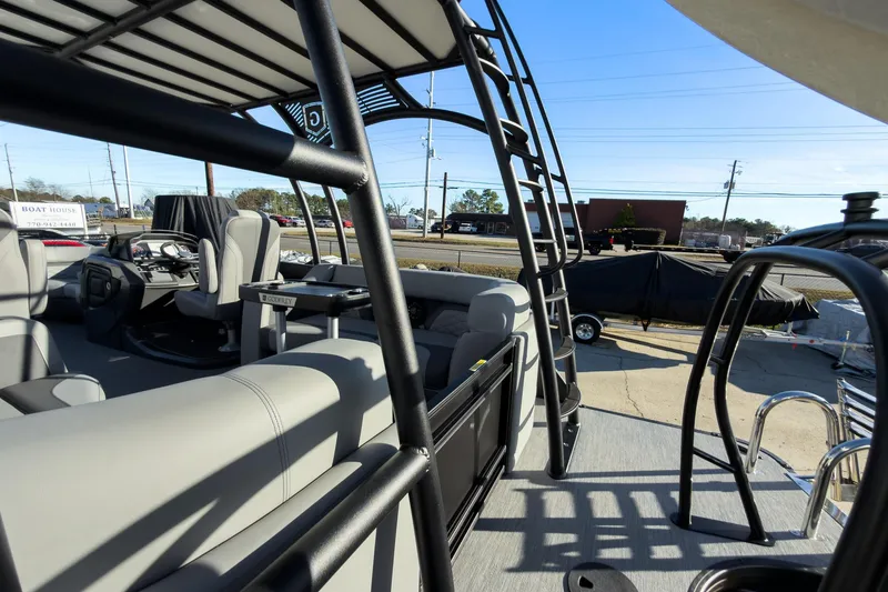 Slide: The Image of 2026 Godfrey Monaco 235 Sun Deck boat interior with seating and helm, parked outdoors. - 64