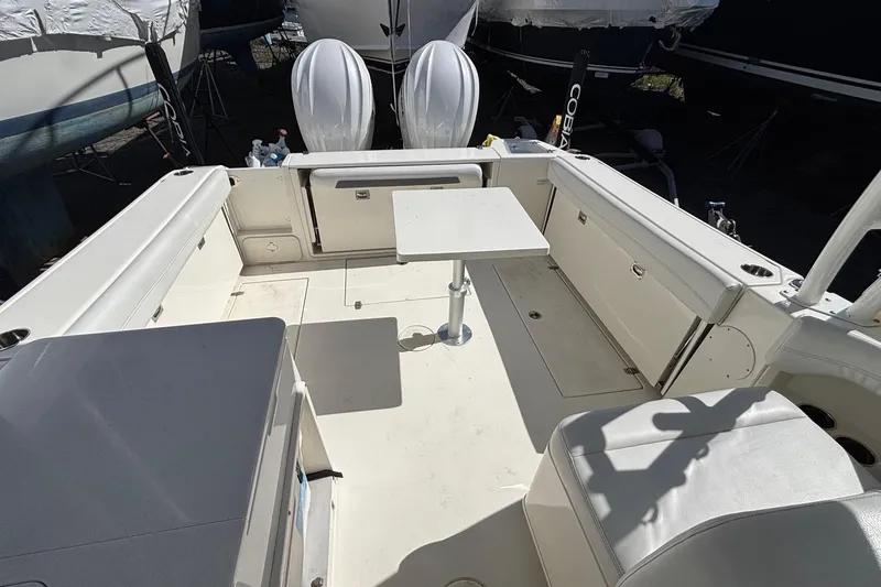 Slide: The Image of 2024 Cobia 280 Dual Console boat interior with seating and table setup. - 11