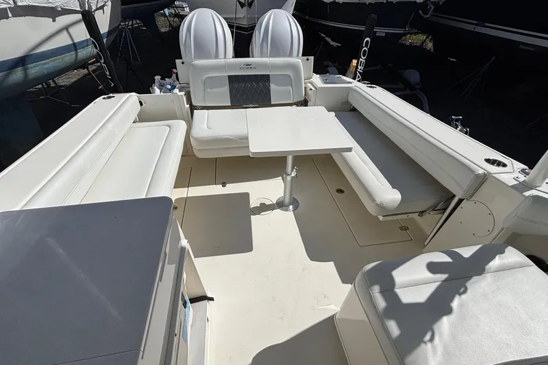 Slide: The Image of 2024 Cobia 280 Dual Console boat interior with seating and table setup. - 12