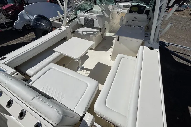 Slide: The Image of 2024 Cobia 280 Dual Console boat interior with seating and table, featuring Yamaha engine. - 13