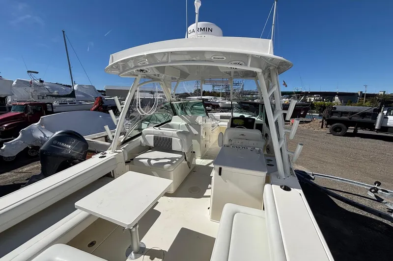 Slide: The Image of 2024 Cobia 280 Dual Console boat with Yamaha engine, docked under clear blue sky. - 14