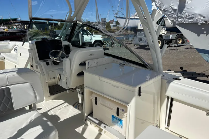 Slide: The Image of 2024 Cobia 280 Dual Console boat interior with helm, seating, and storage area. - 15