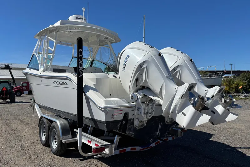 Slide: The Image of 2024 Cobia 280 Dual Console boat with twin Yamaha engines on a trailer. - 17