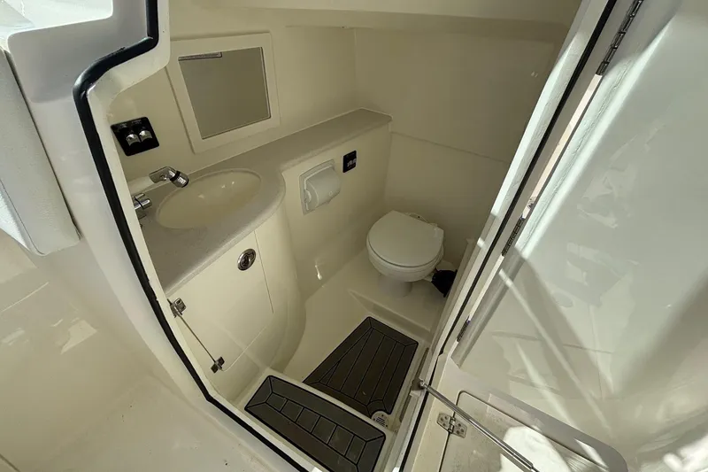 Slide: The Image of 2024 Cobia 280 Dual Console boat bathroom with sink, toilet, and mirror. - 22