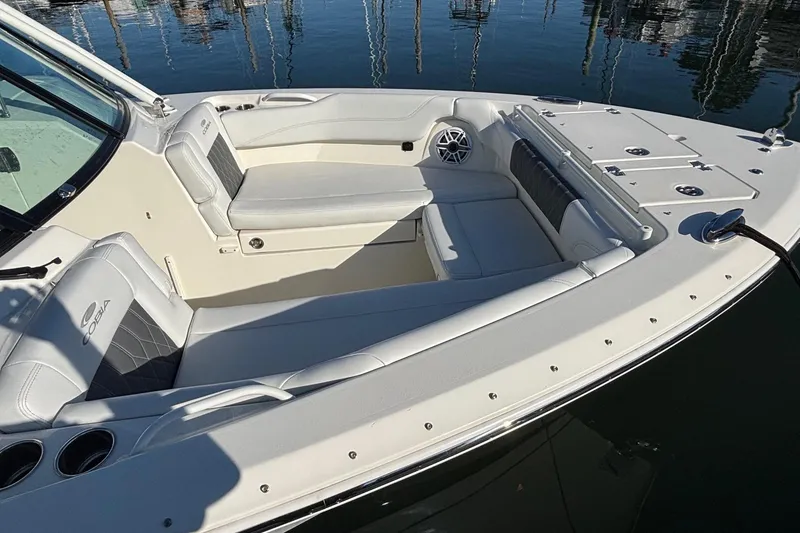 Slide: The Image of 2024 Cobia 280 Dual Console boat interior with white seating and cup holders. - 4