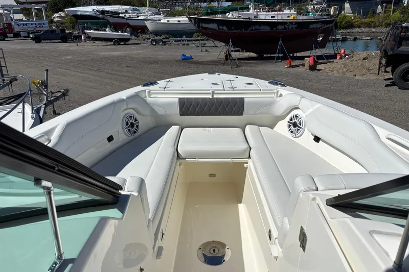 Slide: The Image of 2024 Cobia 280 Dual Console boat interior with white seating and speakers. - 7