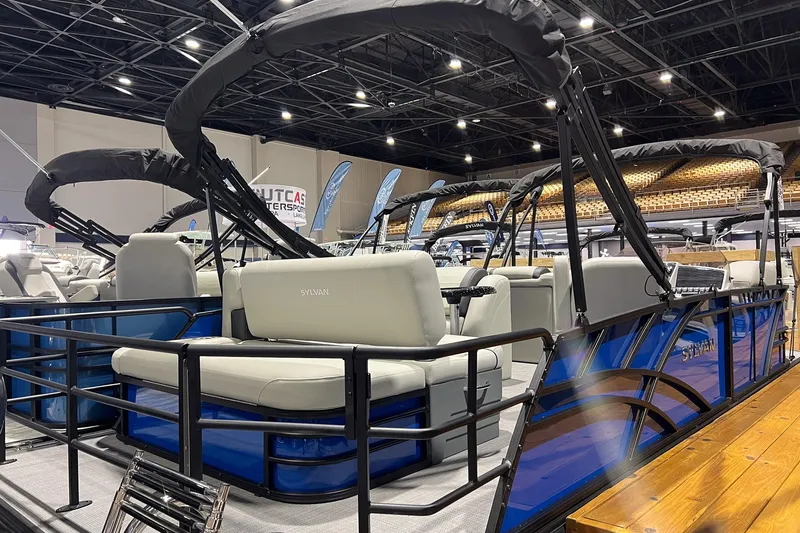 The Image of 2026 Sylvan Mirage 822 CLZ pontoon boat displayed indoors with sleek design and seating. - 0