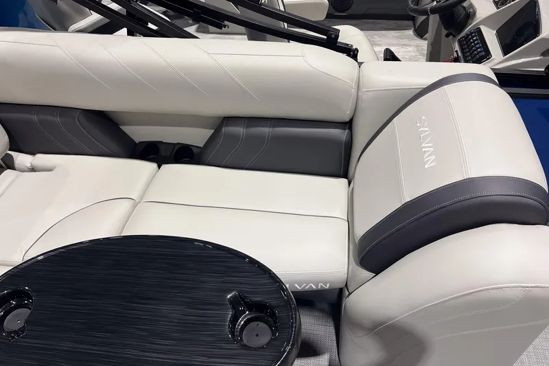 Slide: The Image of 2026 Sylvan Mirage 822 CLZ boat interior with luxurious seating and sleek table design. - 11