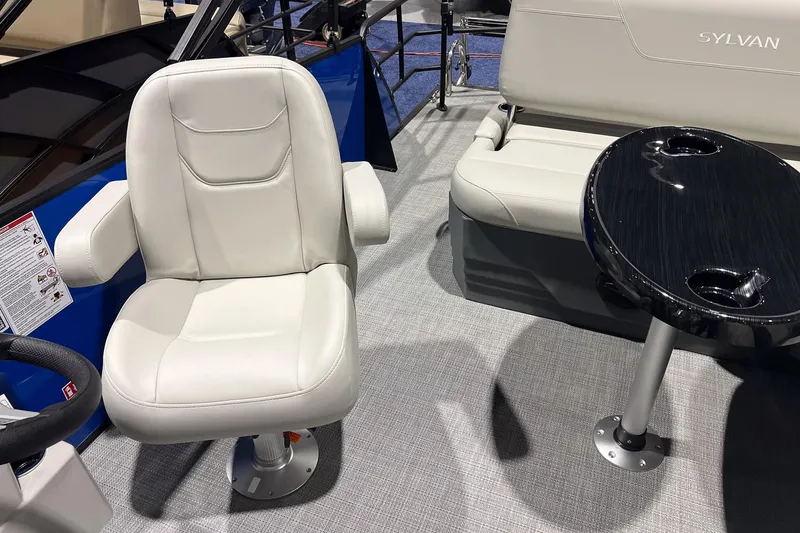 Slide: The Image of 2026 Sylvan Mirage 822 CLZ boat interior with white seating and black table. - 14