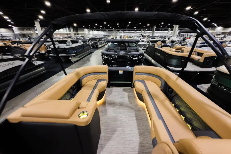 Slide: The Image of 2026 Godfrey Monaco 255 Sun Deck boat interior at a showroom, featuring luxurious seating. - 31