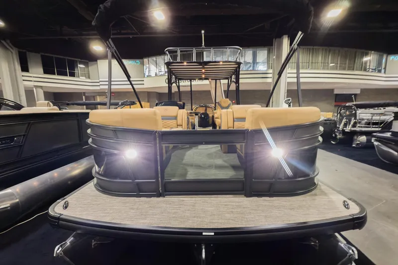 Slide: The Image of 2026 Godfrey Monaco 255 Sun Deck boat displayed indoors with illuminated deck lights. - 6