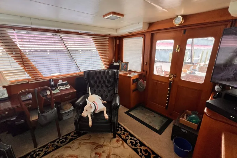 Slide: The Image of Interior of 1985 Hartman-Palmer yacht with dog on chair, wooden decor, and large windows. - 18