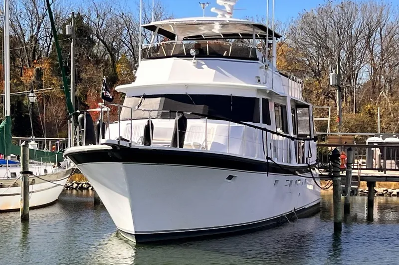 Slide: The Image of 1985 Hartman-Palmer 60 Flush Deck Motor Yacht docked in a serene marina. - 2