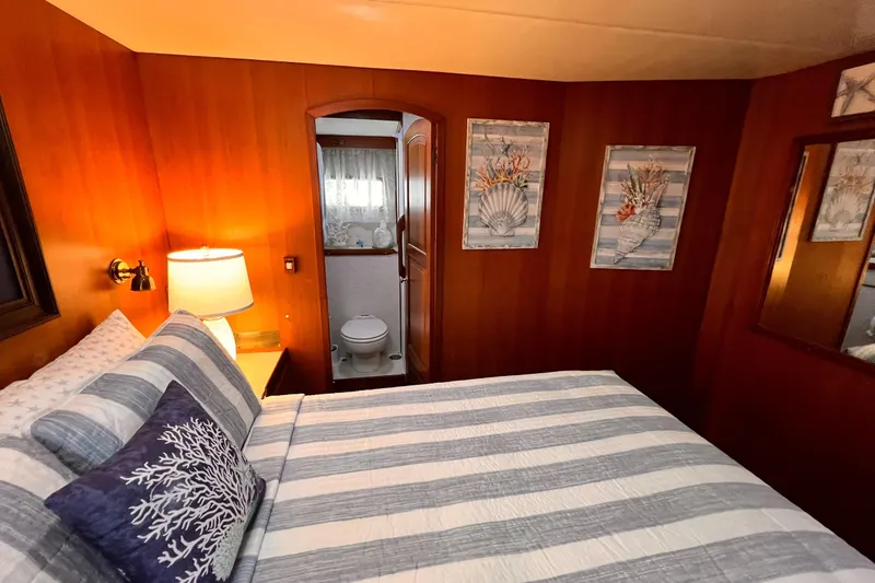 Slide: The Image of Cozy bedroom on 1985 Hartman-Palmer yacht with striped bedding and nautical decor. - 37