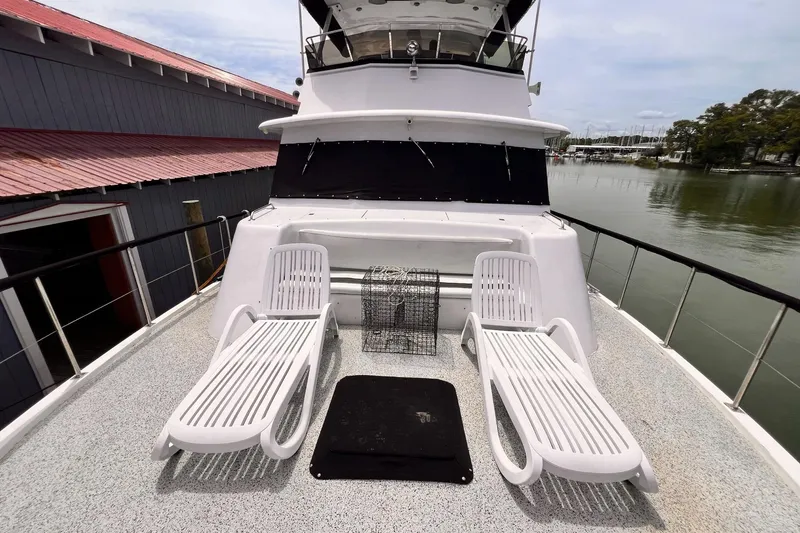 Slide: The Image of 1985 Hartman-Palmer 60 Flush Deck Motor Yacht with sun loungers on deck, docked by the water. - 4