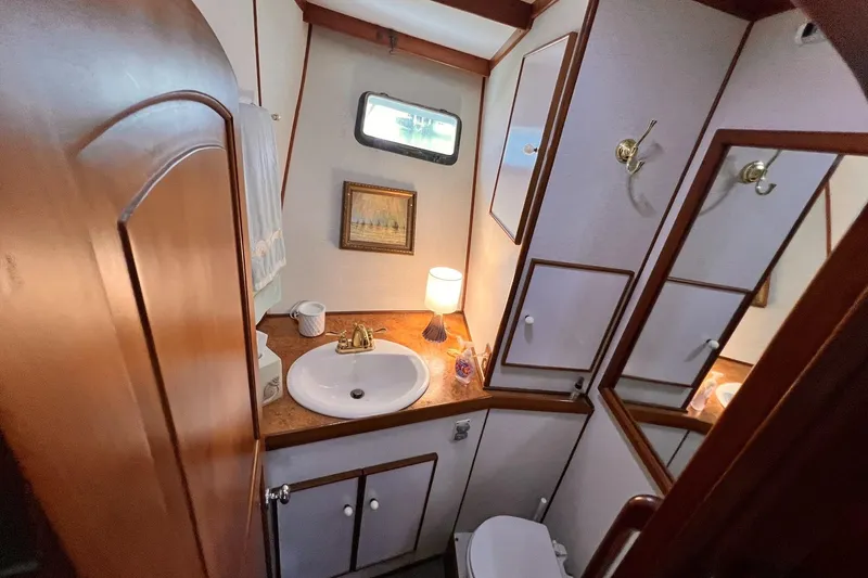 Slide: The Image of 1985 Hartman-Palmer yacht bathroom with sink, mirror, and wooden cabinetry. - 46