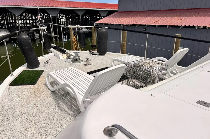 Slide: The Image of 1985 Hartman-Palmer 60 Flush Deck Motor Yacht with deck chairs and dock view. - 5