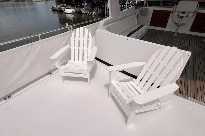 Slide: The Image of Two white Adirondack chairs on the deck of a 1985 Hartman-Palmer motor yacht. - 8