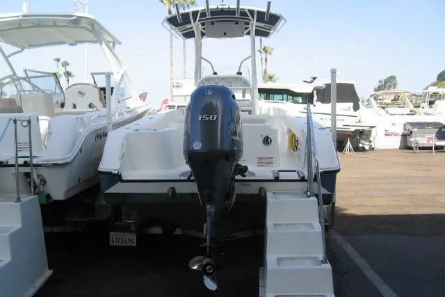Slide: The Image of 2024 Edgewater 208CC boat with Yamaha 150 engine, docked at a marina. - 12