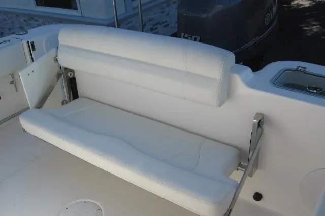 Slide: The Image of 2024 Edgewater 208CC boat with white cushioned seating and outboard motor. - 8