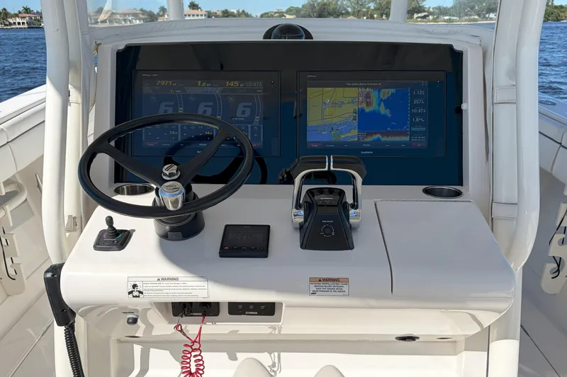 Slide: The Image of 2018 Jupiter 38 FS boat helm with steering wheel, dual screens, and control panel. - 16