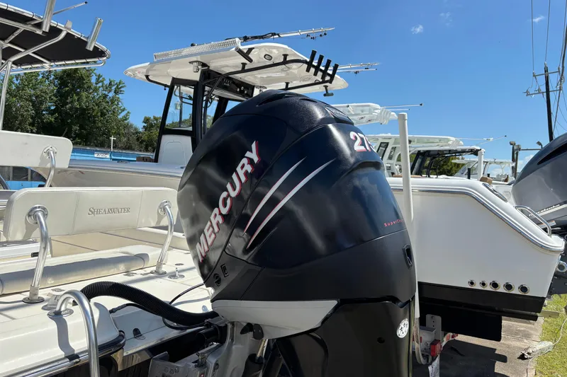 Slide: The Image of 2006 Shearwater Boatworks 2400Z with Mercury outboard motor, docked under clear blue sky. - 6