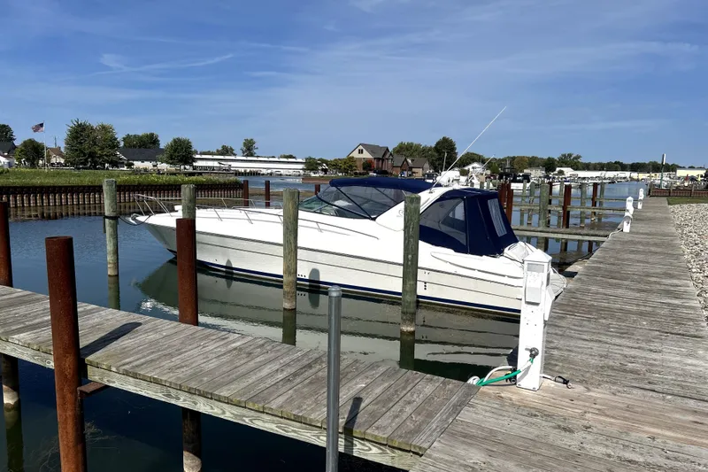 The Image of 2004 Wellcraft 47 Excalibur yacht docked at a marina under clear blue skies. - 0