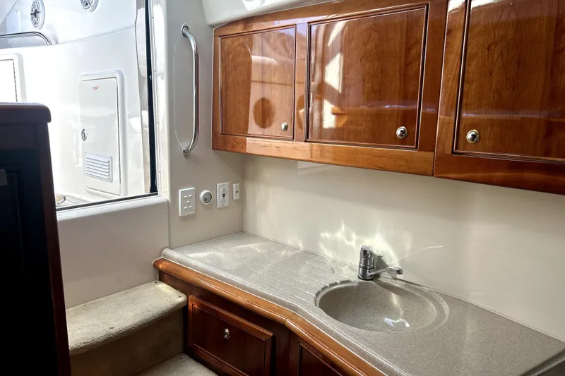 Slide: The Image of Interior of 2004 Wellcraft 47 Excalibur yacht with wooden cabinets and sink. - 24