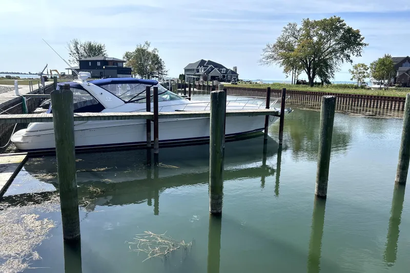 Slide: The Image of 2004 Wellcraft 47 Excalibur docked in a serene marina setting. - 3