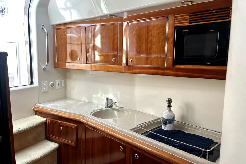 Slide: The Image of Luxurious 2004 Wellcraft 47 Excalibur yacht interior with wooden cabinets and modern amenities. - 34